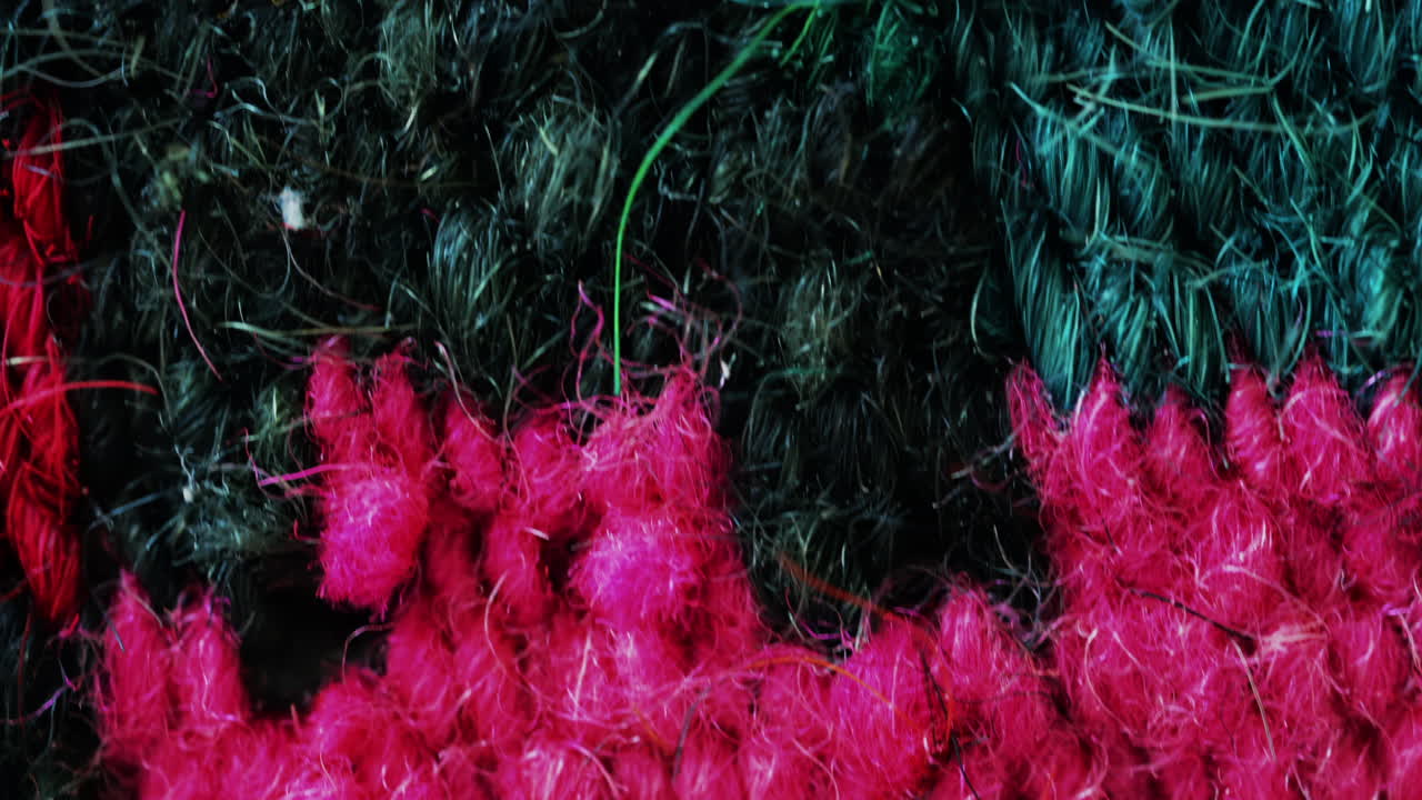 Intense pink and red wool fibers form a rich, detailed texture