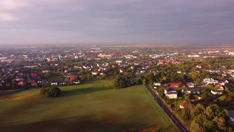 Aerial-view-of-residential-suburbs-separated-by-a-road-from-the-field