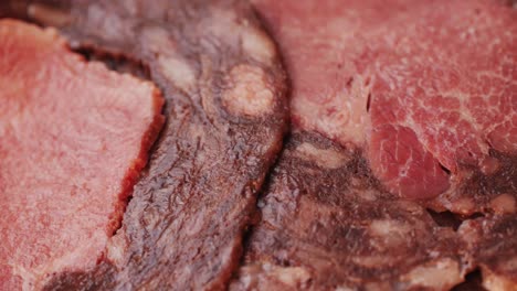 black bull sausage ham, tongue pork dry-cured sausage on a black background, traditional spanish delicatessen food, close up.