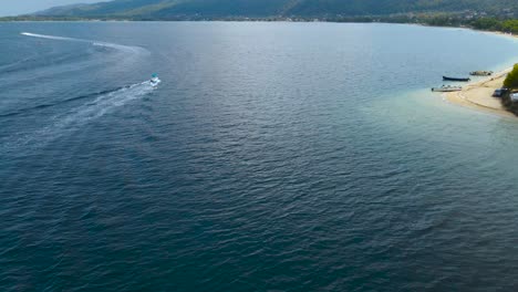 Rotating-drone-clip-over-a-boat-and-an-island-in-the-bay-of-Vourvourou,-Halkidiki,-Northern-Greece