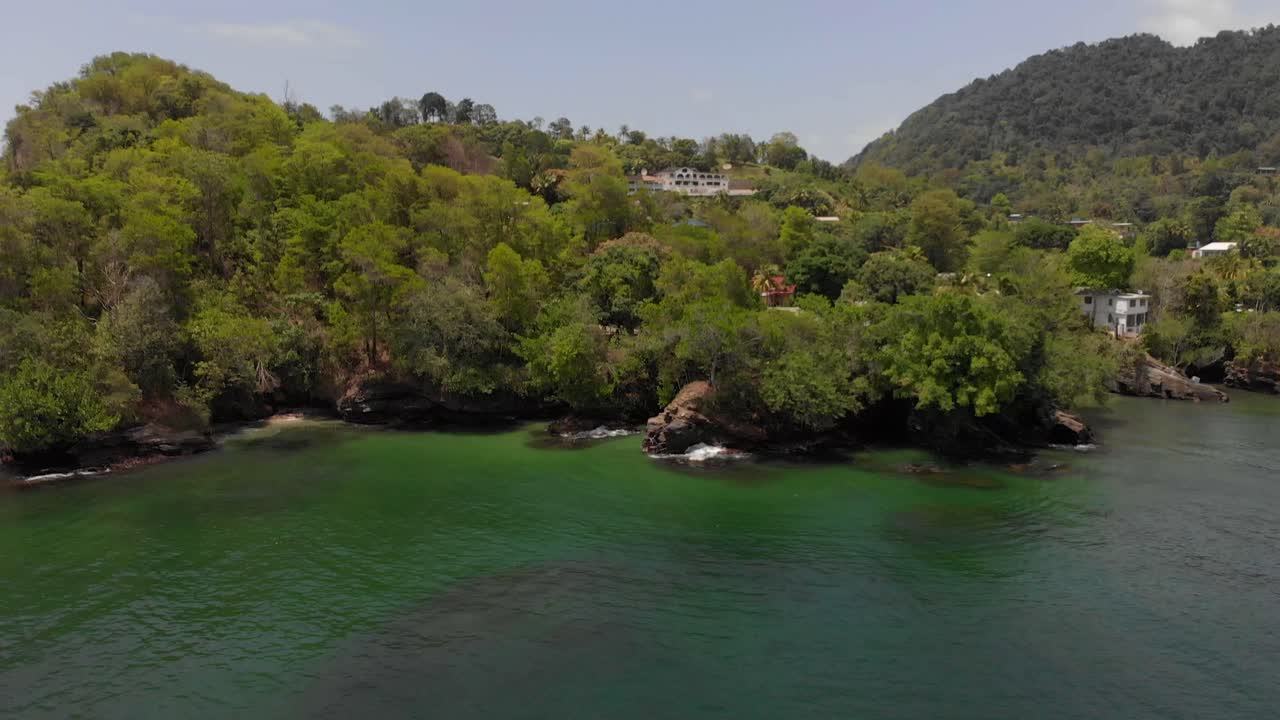 Riprese con drone di un villaggio di pescatori sul fianco di una montagna con barche ancorate nella baia