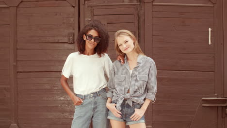 una pareja de lesbianas multiétnicas posando al aire libre