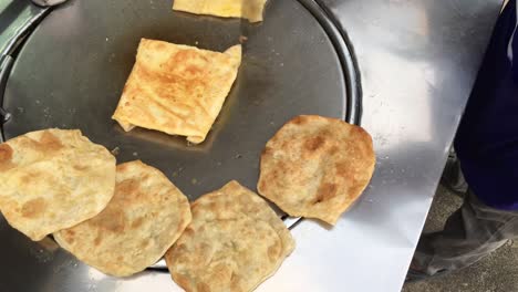 cooking exotic thai pancakes, malaysian roti with different stuffing on a  market in thailand. making eggs roti roll on hot metal pans with boiled oil. street food food of thailand. thai dessert.