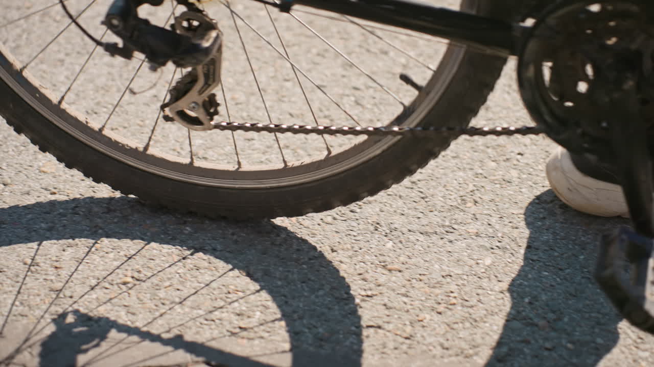 Ciclista na estrada, entregador de delivery ajustando o equipamento, entregador de bicicleta percorrendo a rua da cidade durante o dia, entregador andando pelas ruas da cidade com luz solar e atmosfera movimentada
