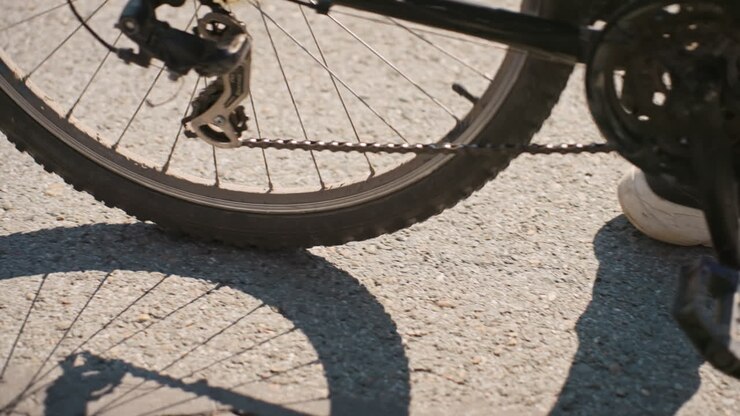 Ciclista su strada, fattorino delle consegne che sistema l'attrezzatura, corriere in bicicletta che si muove per le vie della città durante le ore diurne, addetto alle consegne che pedala tra le vie della città con la luce del sole e un'atmosfera vivace