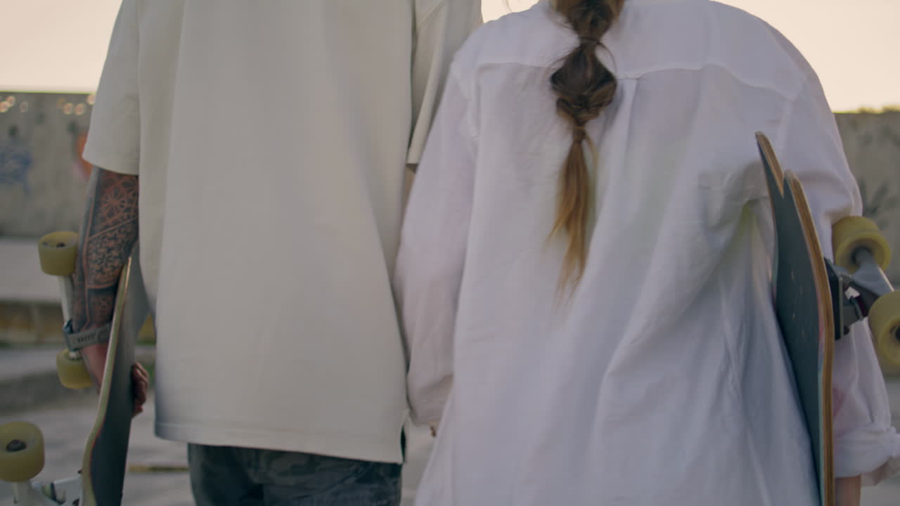 웃는 커플이 멀리서 은 곳을 가게 보고 있다. 스케이트 선수들이 경기장을 고 있다.