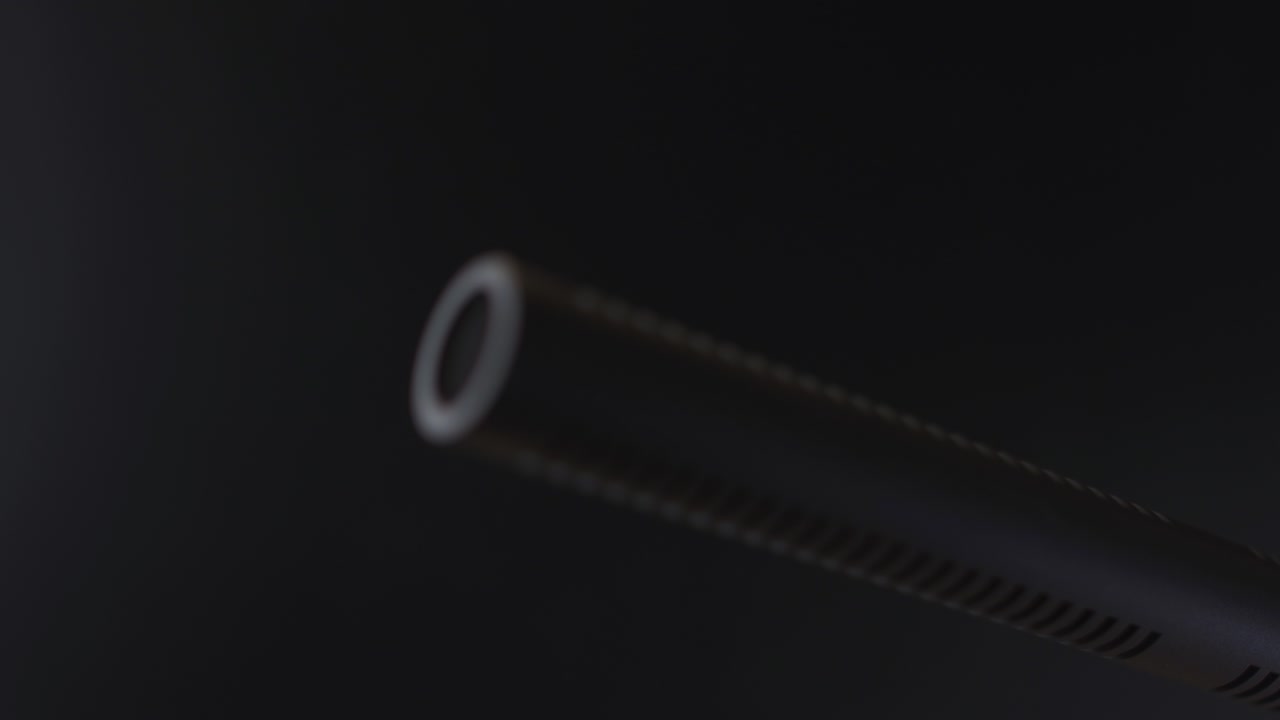 крупный план наконечника конденсаторного микрофона, скрытого в темноте