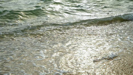 hermosa playa con olas que llegan a la orilla de una playa de arena blanca en un tropical durante una puesta de sol