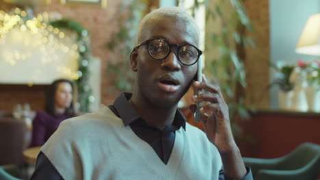 african american businessman talking on phone in cafe