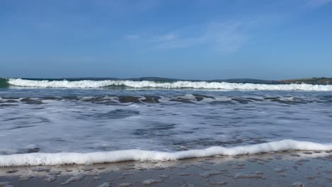 low angle footage of a wave on a sandy beach