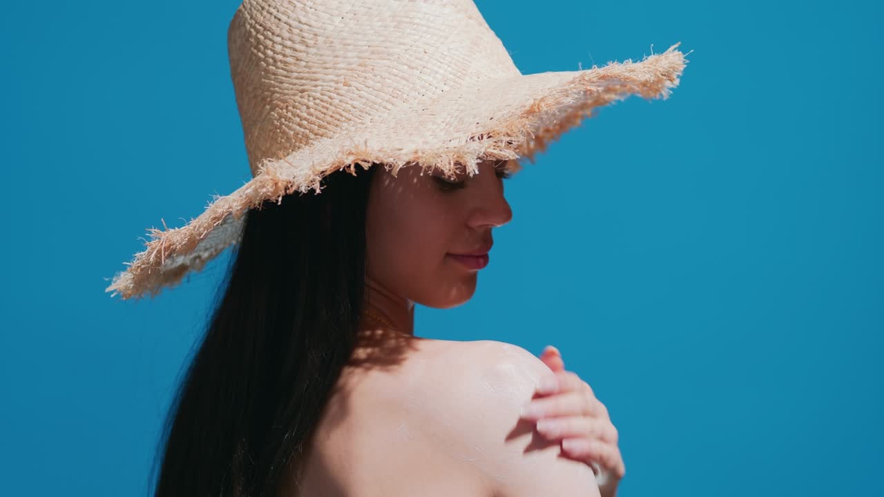 Young asian woman applying sunscreen on shoulder enjoys the sun
