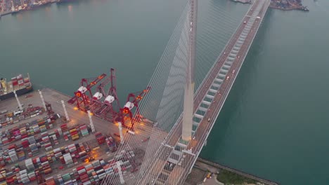 high-angle footage of a bustling shipping port featuring rows of organized cargo containers and towering cranes used for maritime logistics. adjacent to the port