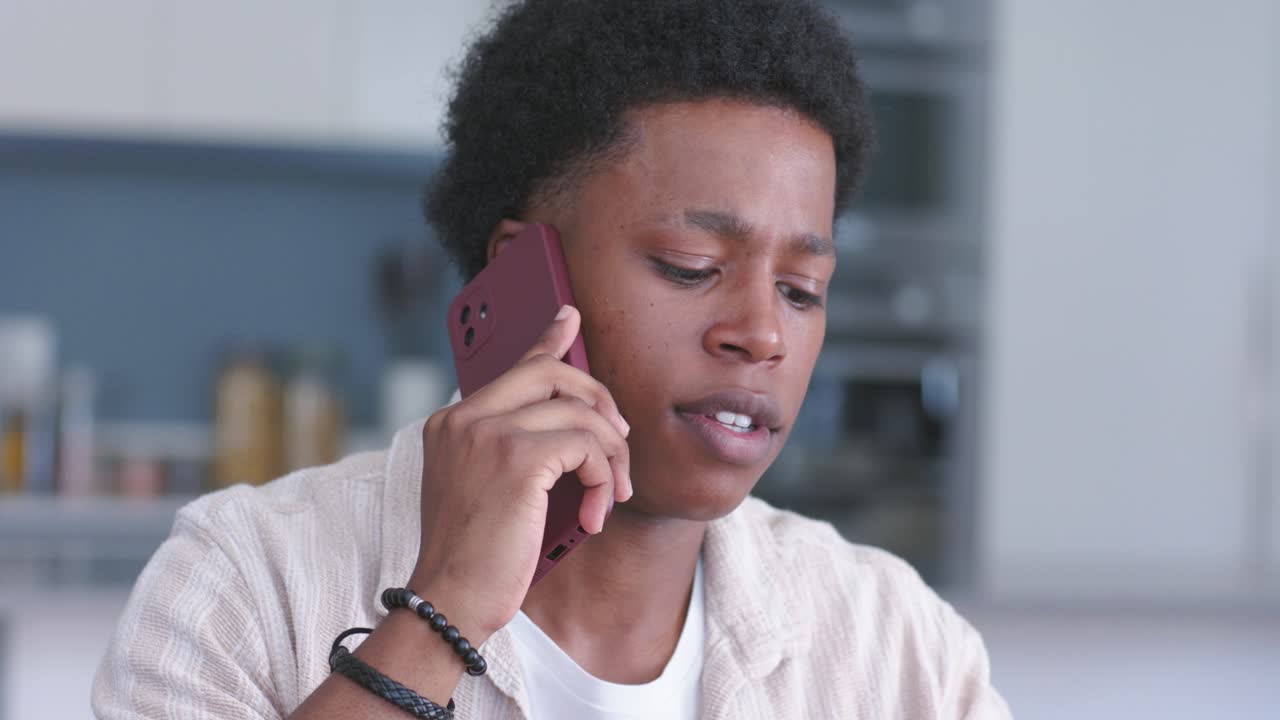 Pria Afrika-Amerika menjawab telepon berdering, memeriksa laptop dan catatan di dapur, memperjelas tugas.