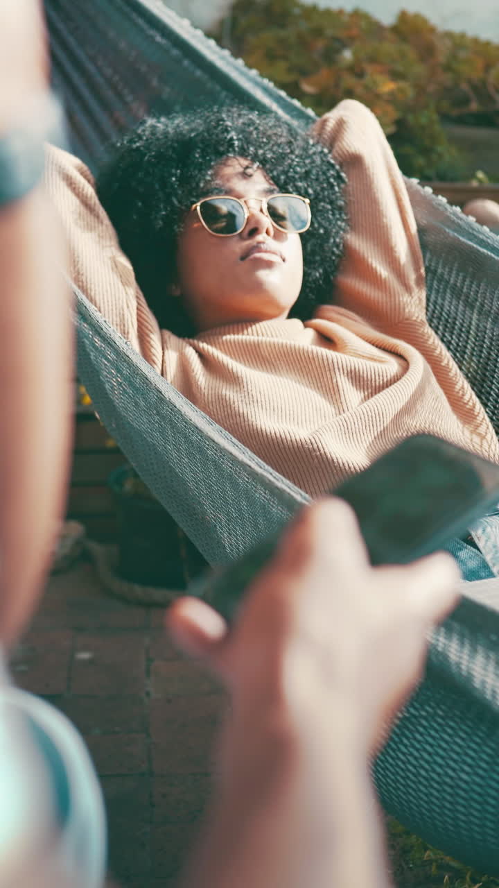 Young Woman with Curly Hair Relaxing in a Hammock Outdoors