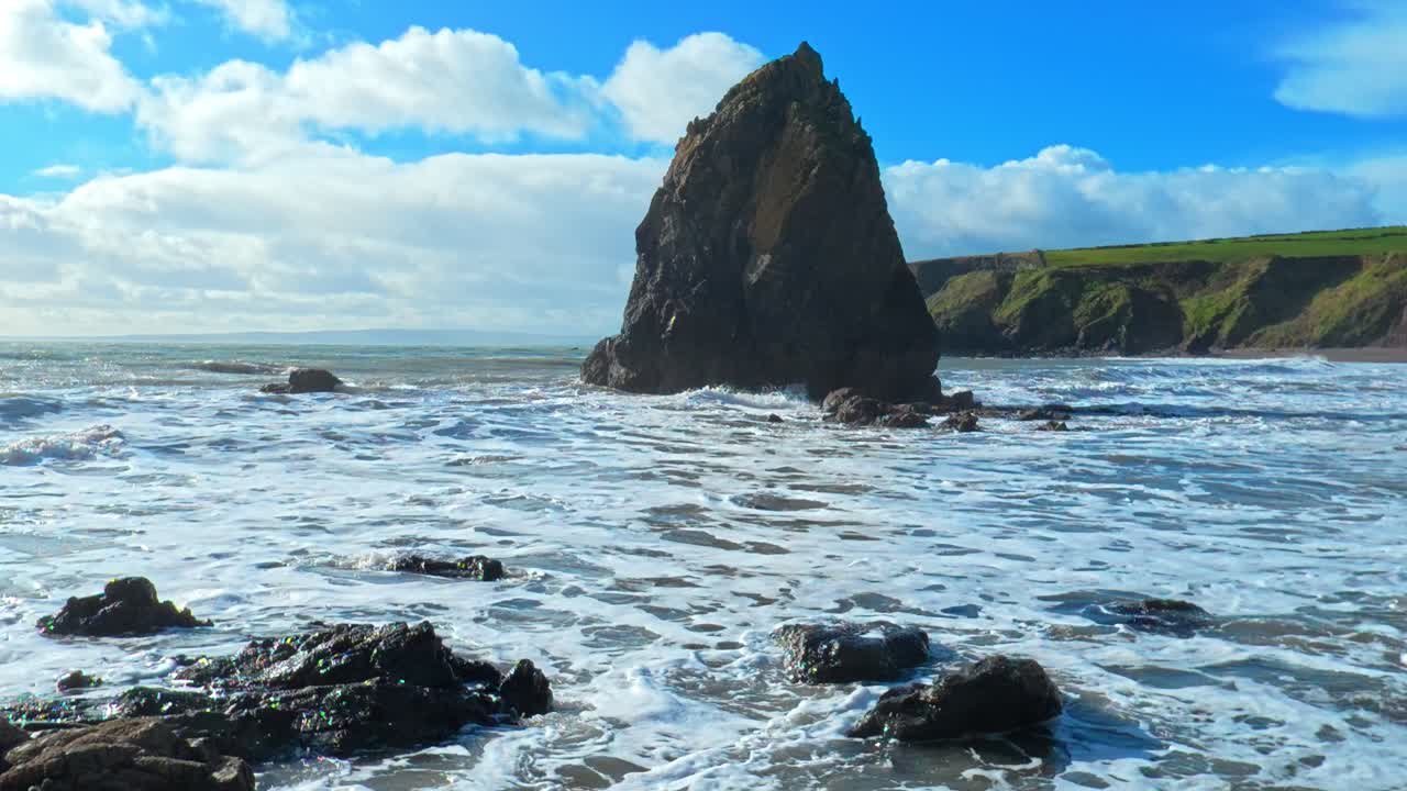 Indkommende bølger, stor havstabel, drivende skyer på blå himmel, forårsmorgen ved Waterfords kyst, Irland – episke lokationer.
