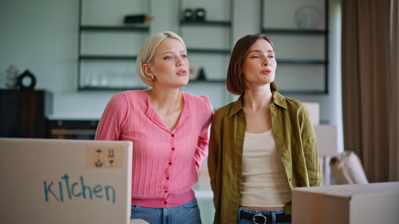 Müde WohnungsmieterInnen packen Kisten aus, Nahaufnahme des Wohnzimmers. Paar übergibt Schlüssel