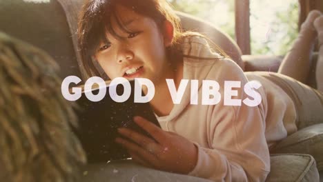 animation of good vibes text over asian girl using tablet