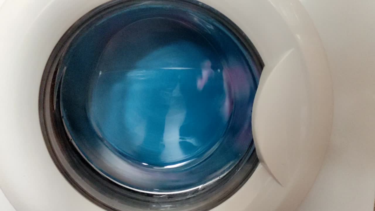 Washing machine washes and spins colorful laundry