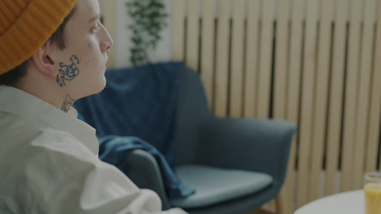 Man with Face and Neck Tattoos in a Cozy Room