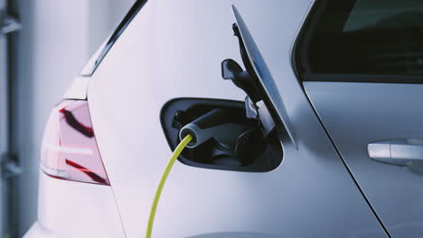 close up of hand removing power cable from environmentally friendly zero emission electric car