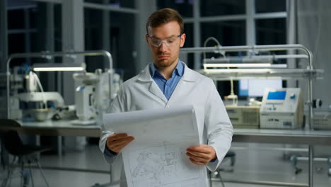 scientist in a lab examining a blueprint