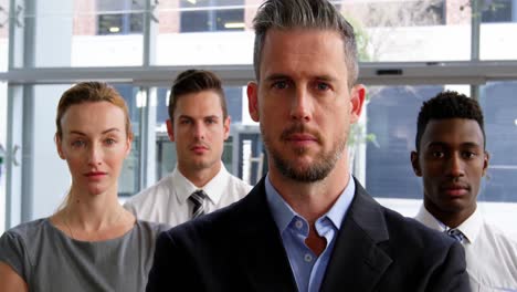 Businesspeople-standing-with-arms-crossed-in-office