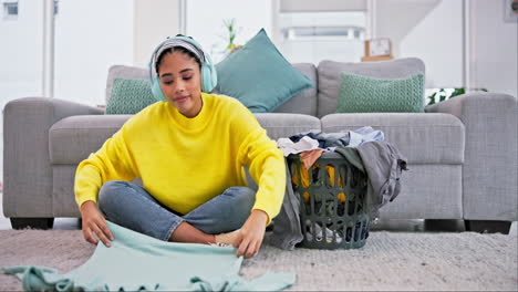 Laundry,-headphones-and-woman-fold-clothes