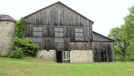 Back-Of-Rural-Wood-Barn-With-Old-Stone-Silo-In-4K