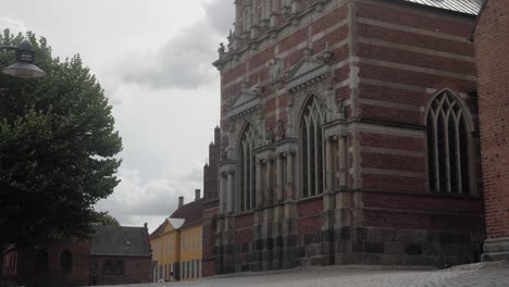 the windows of roskilde cathedral seen from outside the church with a tree and a lamp post