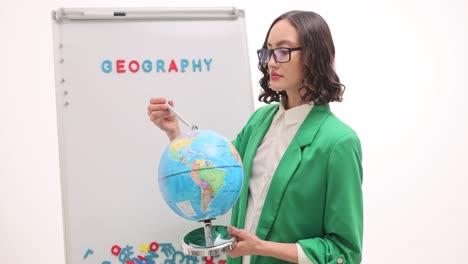 female teacher explaining geography with a globe and whiteboard