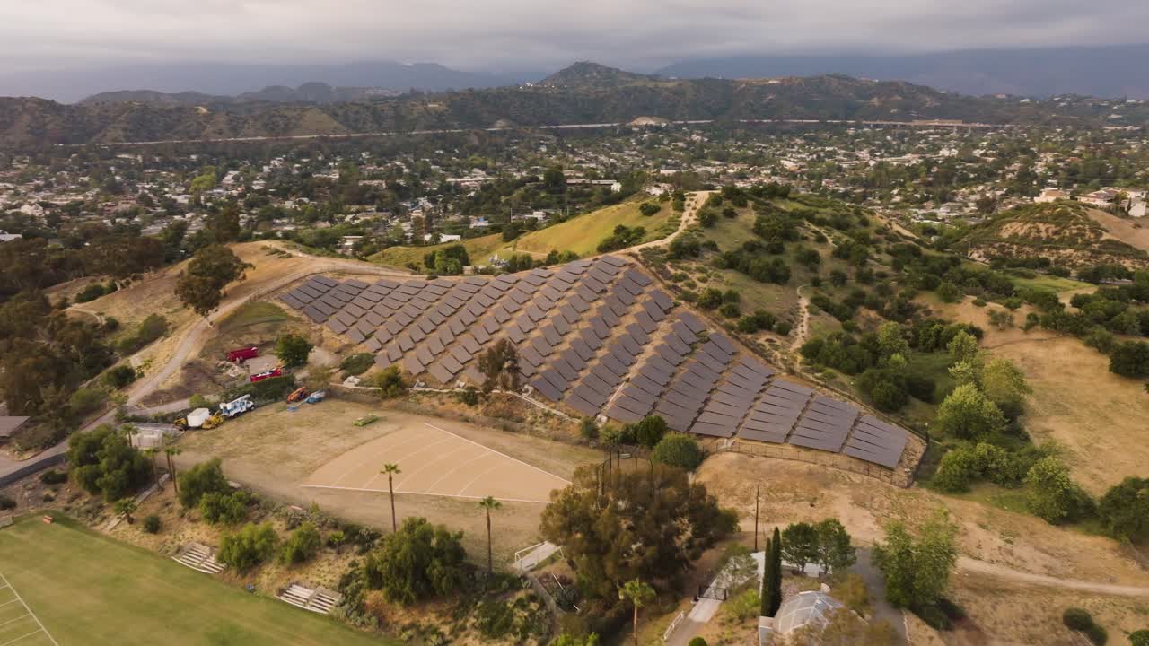 drone view of a solar farm with many panels in Southern California with mountains in the distance