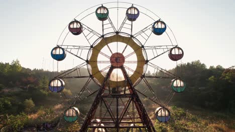 Luftdrohne,-Nahaufnahme-Eines-Verlassenen-Riesenrads-Im-Japanischen-Freizeitpark-Kejonuma,-Sonnige-Japanische-Skyline-In-überwucherten-Feldern,-Aufnahme-Auf-Dem-Land