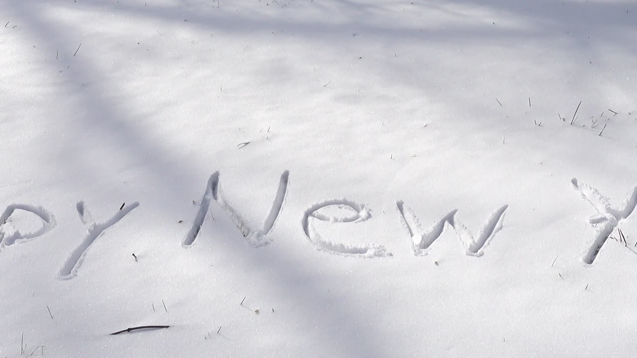Inscription of happy new year on snow. Shooting in the winter