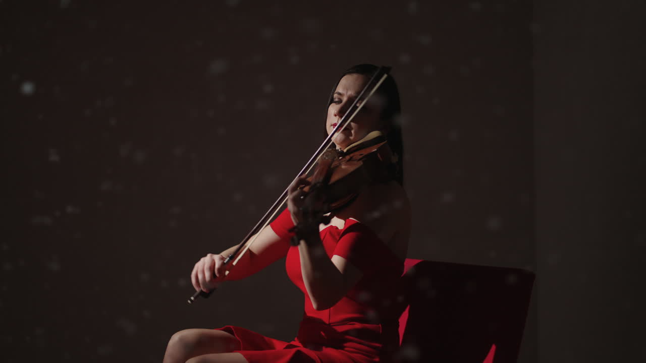 빨간 드레스를 입고 바이올린을 연주하는 여자