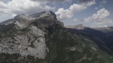 4k locked-heading drone shot of hecho valley and its mountains in the western valleys natural park, aragonese pyrenees, spain. a stunning aerial view of the untouched alpine landscape.