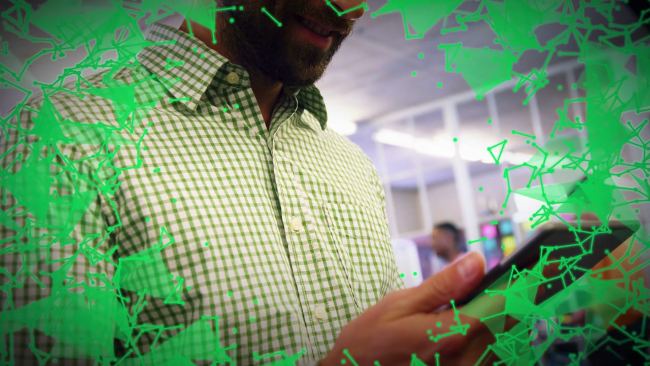 Office worker tapping tablet and swiping, green network overlay expanding as reviewing tech data
