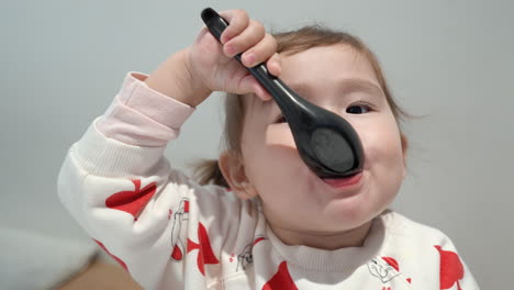 little girl eating with japanese soup spoon