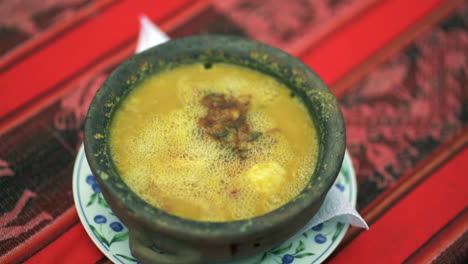 close up top view of hot boiling humita argentine peasant dish served in a casserole, slow motion