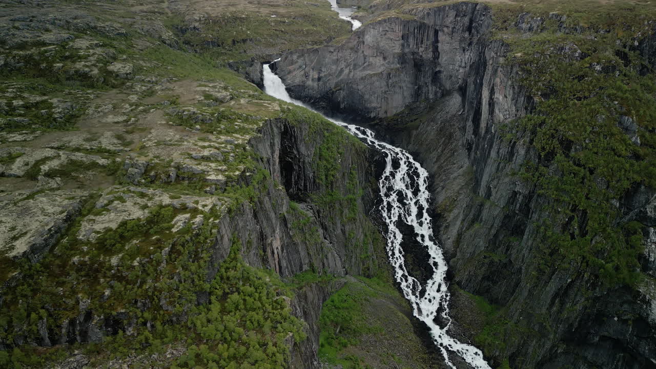 Impressive drone footage of Valurfossen waterfall in Norway. The steep and rugged rocky landscape is visible after the water has plunged into the depths