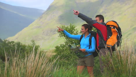 pareja activa caminando juntos con mapa y señalamiento