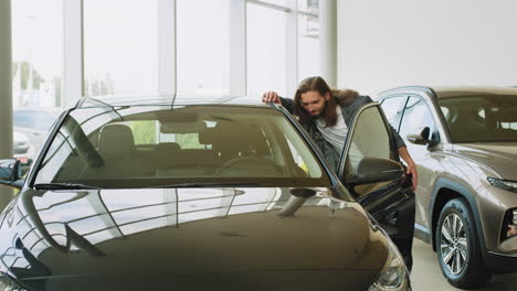 man looking at a car in a showroom