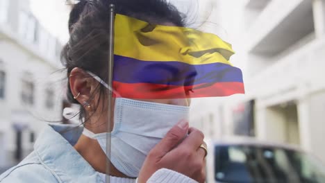 Animation-of-flag-of-colombia-over-woman-wearing-face-mask