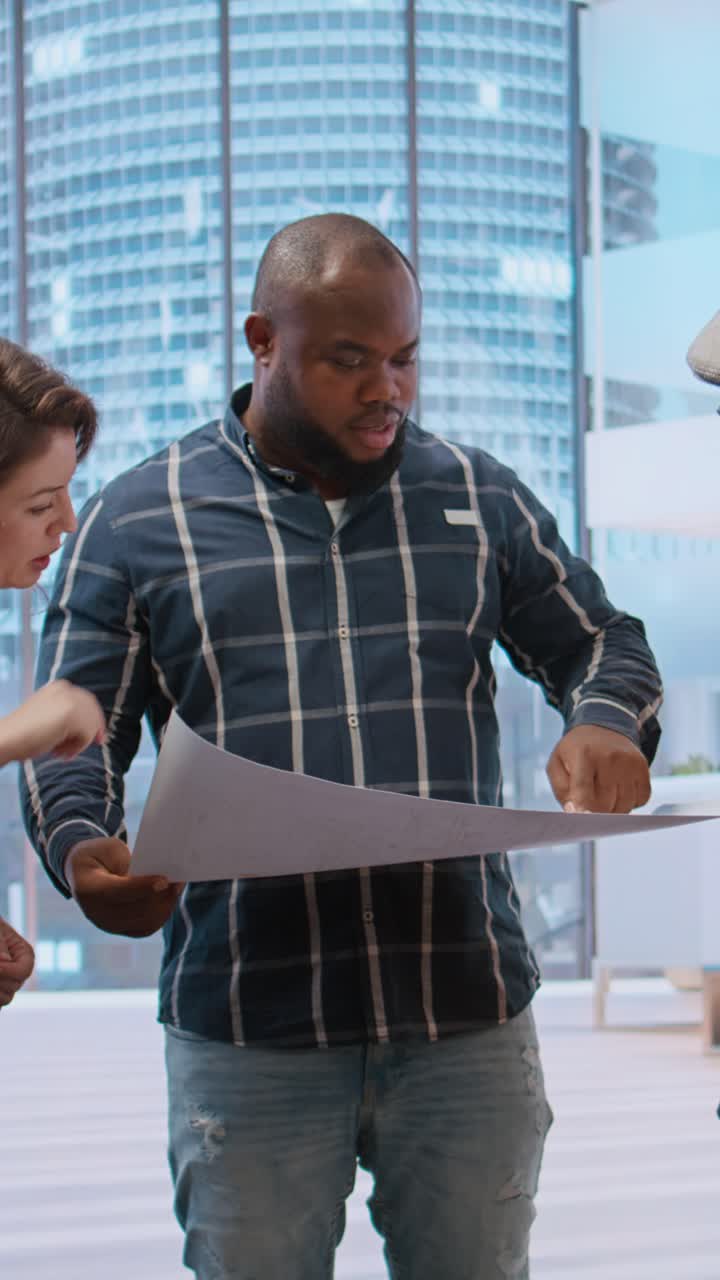 Équipe commerciale diversifiée discutant des plans de projet dans un bureau moderne