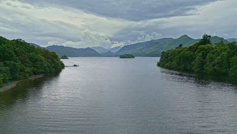 Imágenes-De-Video-Aéreas-De-Drones-De-Derwentwater,-Keswick,-Un-Lago-Tranquilo-Con-Botes-De-Río-Y-Un-Cielo-Tormentoso