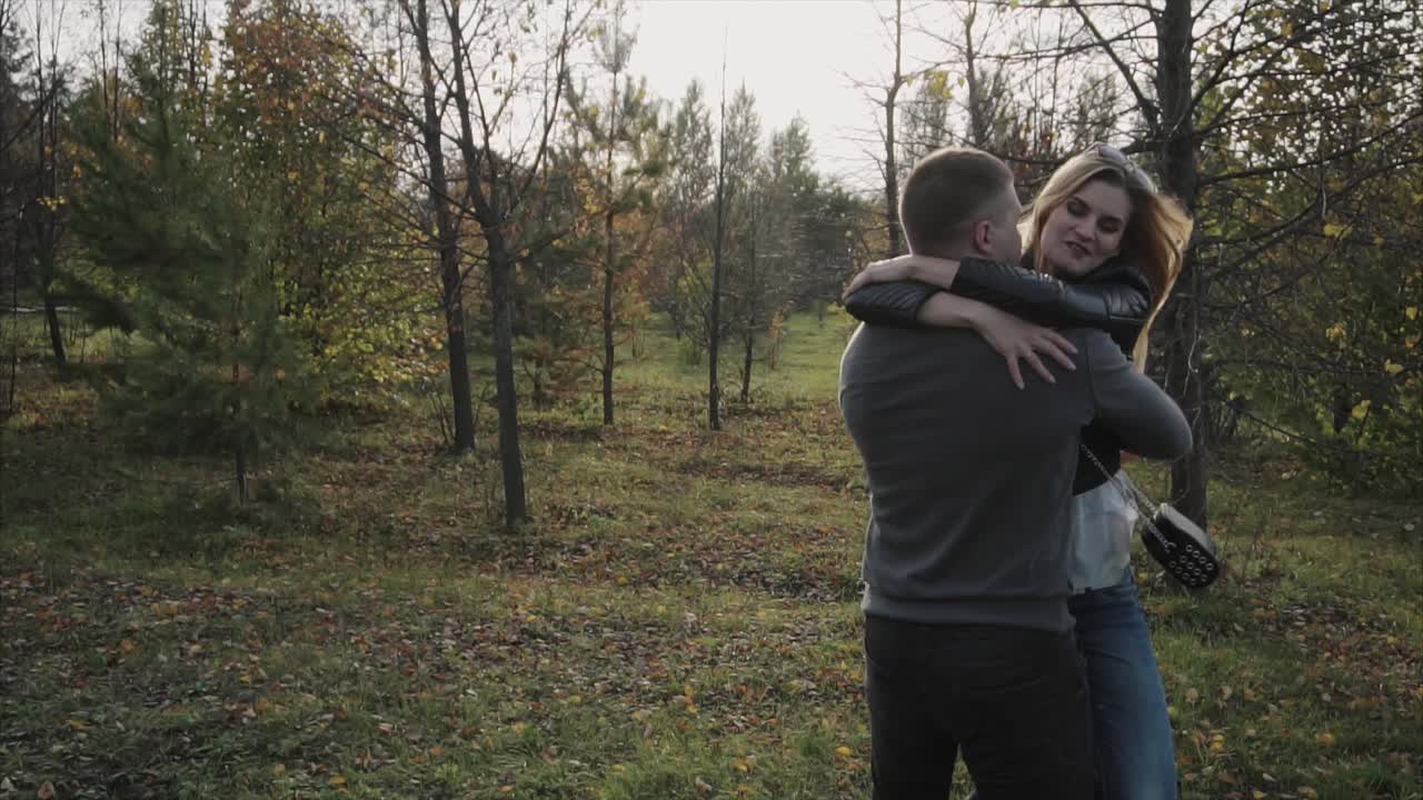 una pareja abrazándose en el parque de otoño.