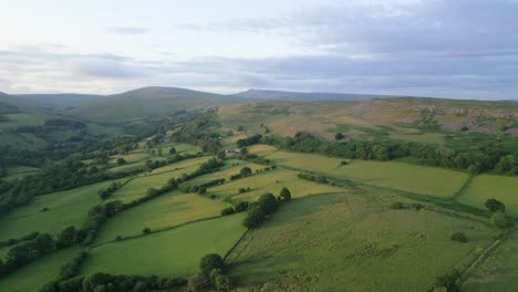 farmland in welsh countryside at sunset, aerial flyover