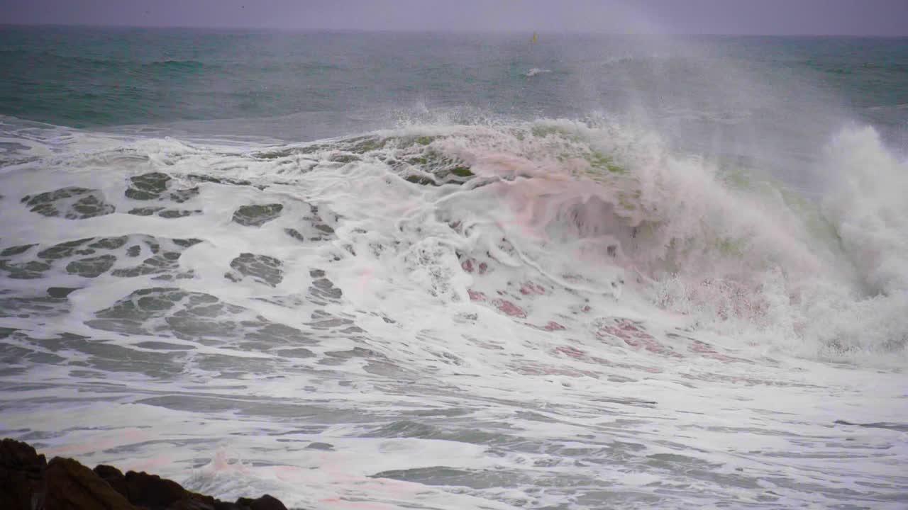 hola en cámara super lenta rompiendo en la costa día nublado tormenta mar embravecido