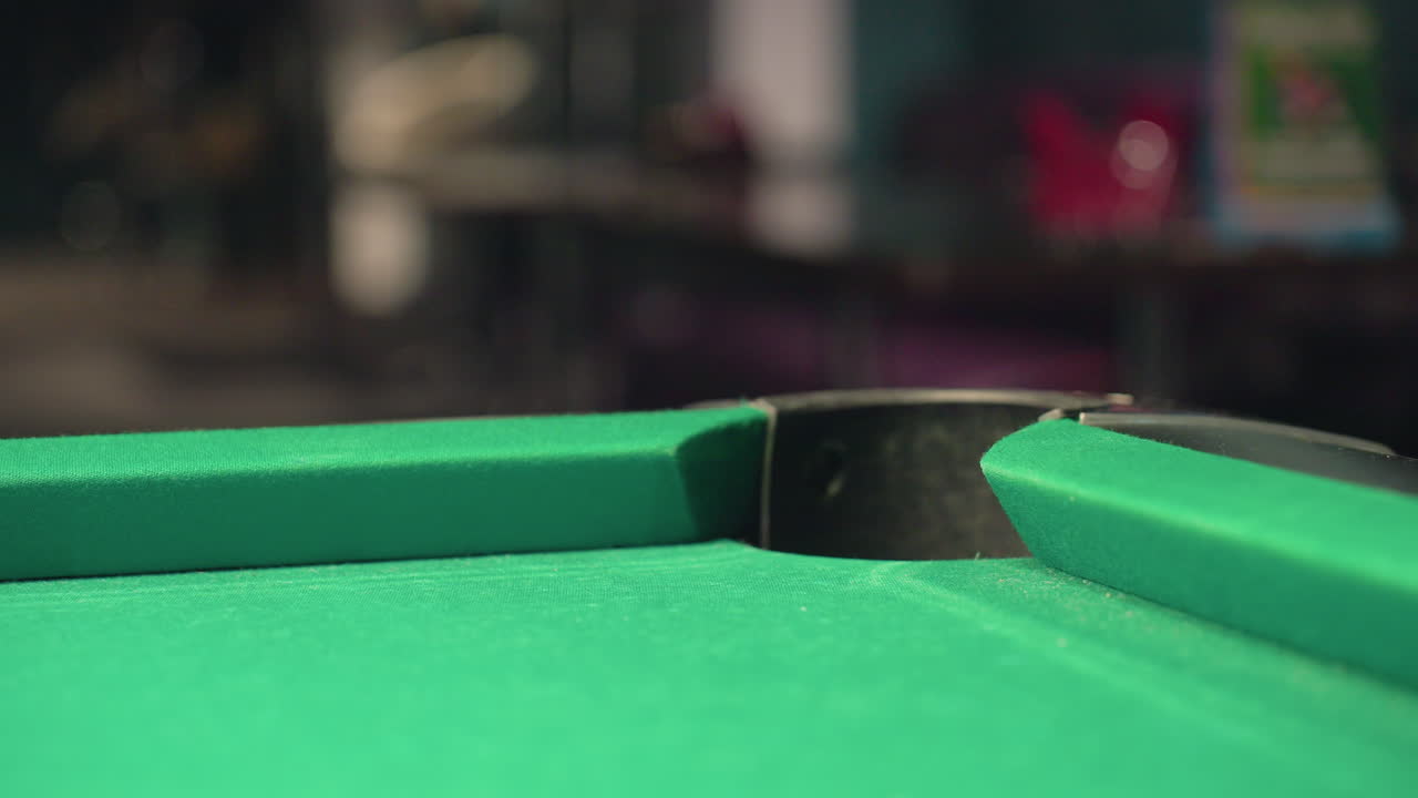 Close-up of red billiard ball rolling towards pocket on green pool table with blurred background. Motion blur emphasizes speed, precision, and intensity of shot, highlighting competition, accuracy