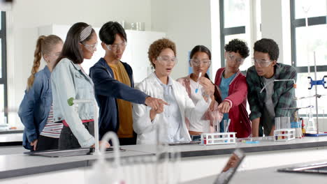 conducting science experiment in high school laboratory, students wearing safety goggles
