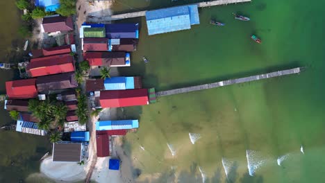 koh rong island in Cambodia, showing colorful stilt houses, piers and fishing boats in turquoise water. Spectacular aerial view flight vertical bird's eye view drone